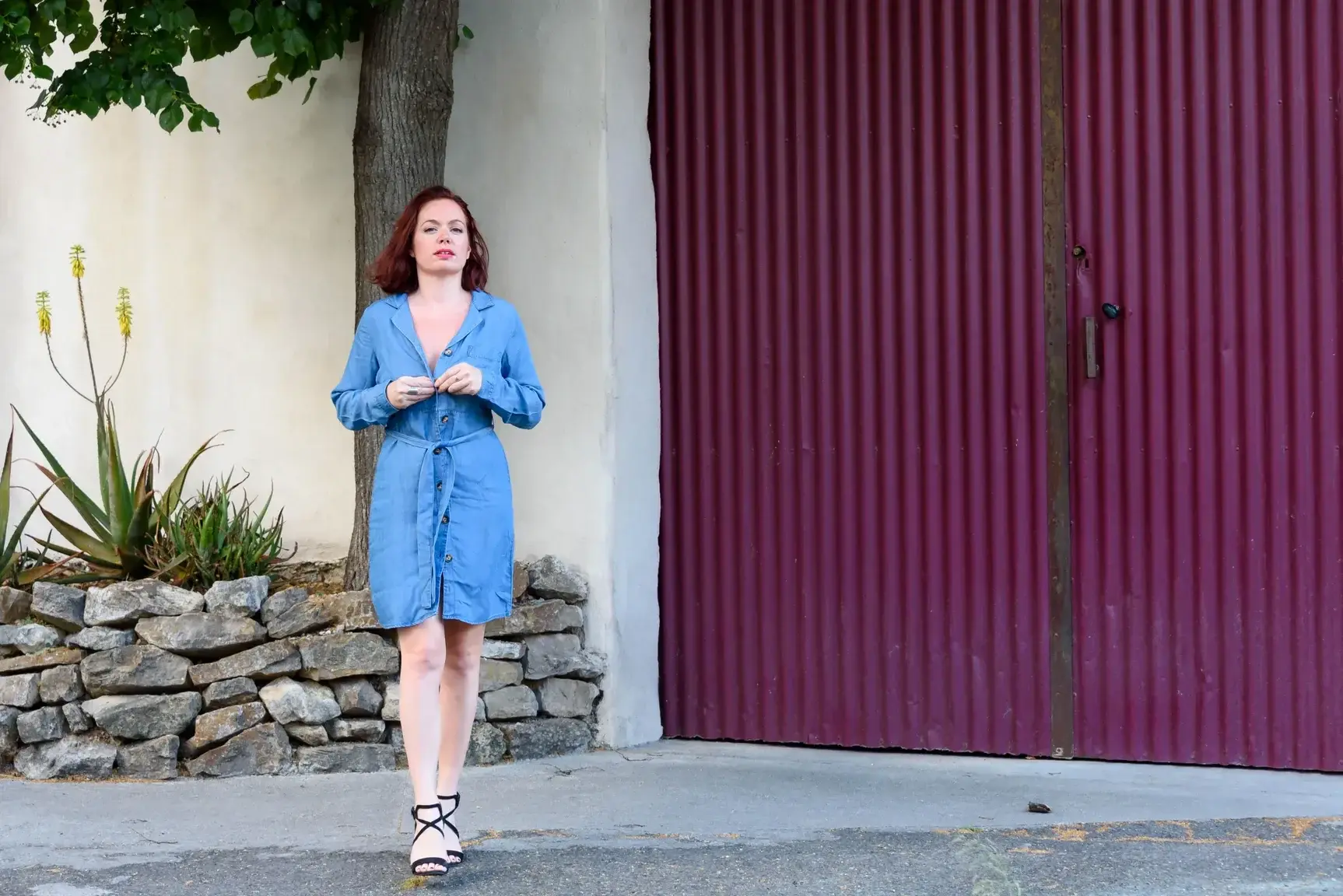 Jeune femme s'apprêtant à ouvrir sa robe dans la rue