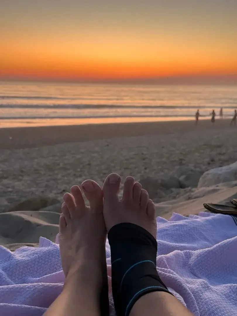 Pieds au coucher du soleil, sur la plage